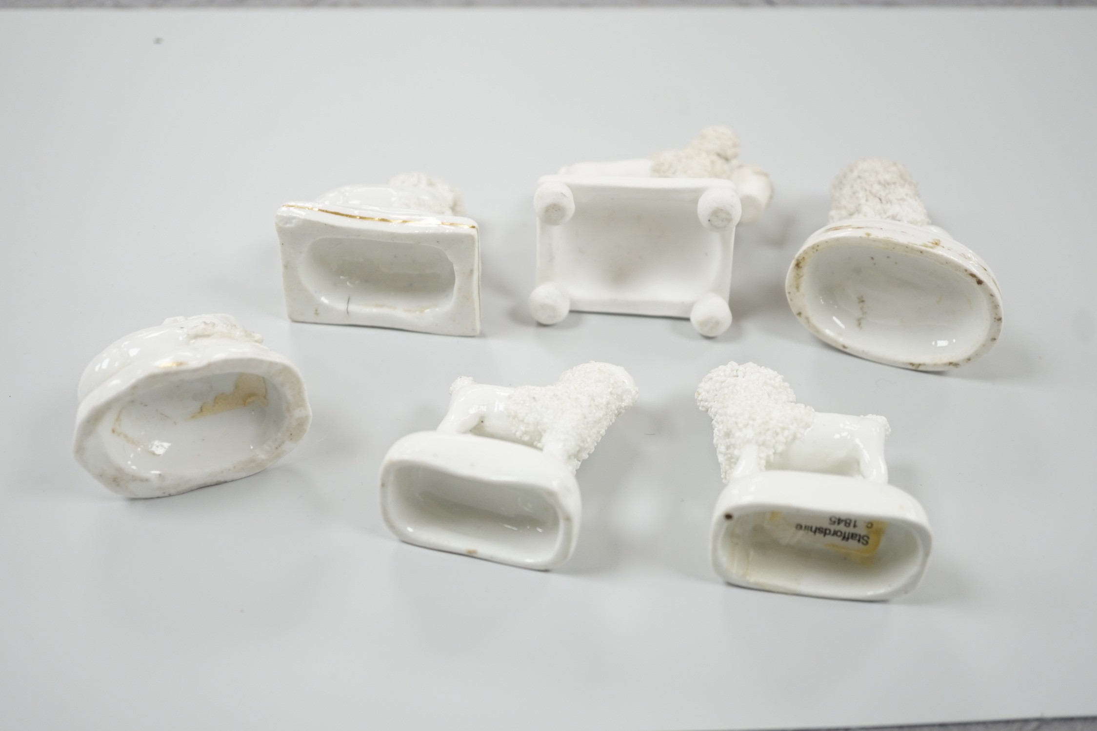 Five small Staffordshire models of poodles, together with a small poodle lying recumbent on an oval mounted base, possibly Davenport, c.1830-50, (6). Tallest 6.8cm., Provence: Dennis G. Rice collection, Cf. Dennis G.Rice